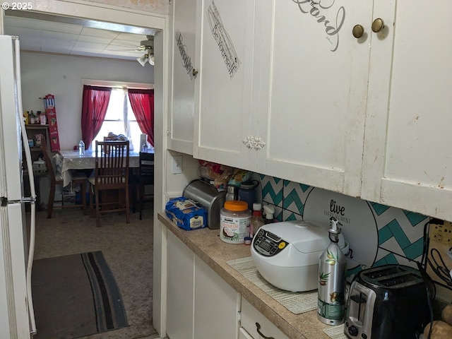 kitchen featuring white cabinetry, ceiling fan, carpet floors, and white refrigerator