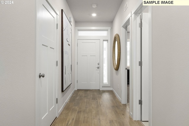 corridor with light hardwood / wood-style floors