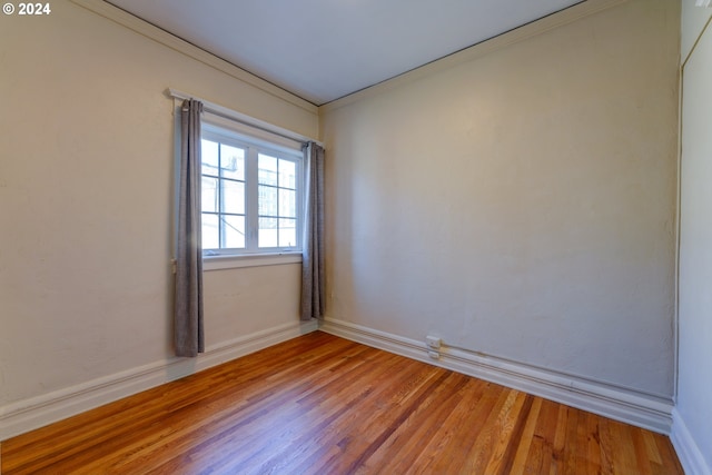 unfurnished room featuring ornamental molding and light hardwood / wood-style floors