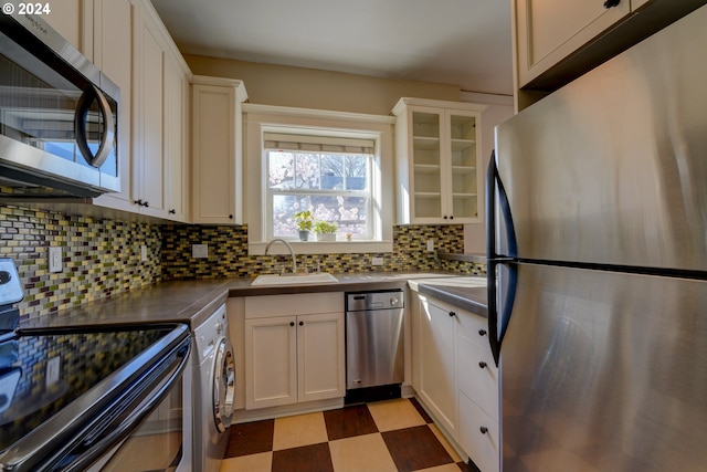 kitchen featuring stainless steel appliances, light tile floors, tasteful backsplash, white cabinets, and sink