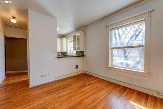 unfurnished room with light wood-type flooring and a healthy amount of sunlight