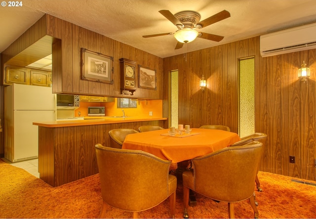 dining room featuring wood walls, light tile flooring, ceiling fan, and a wall mounted AC