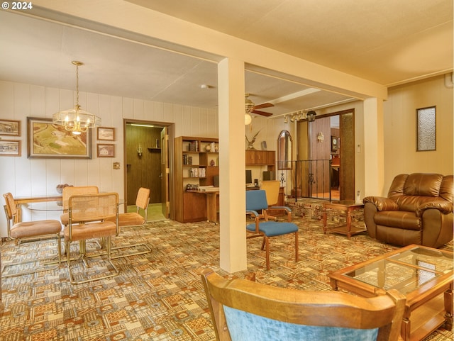 living room with ceiling fan with notable chandelier