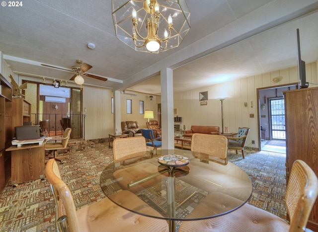 dining area with a textured ceiling, ceiling fan with notable chandelier, and carpet floors