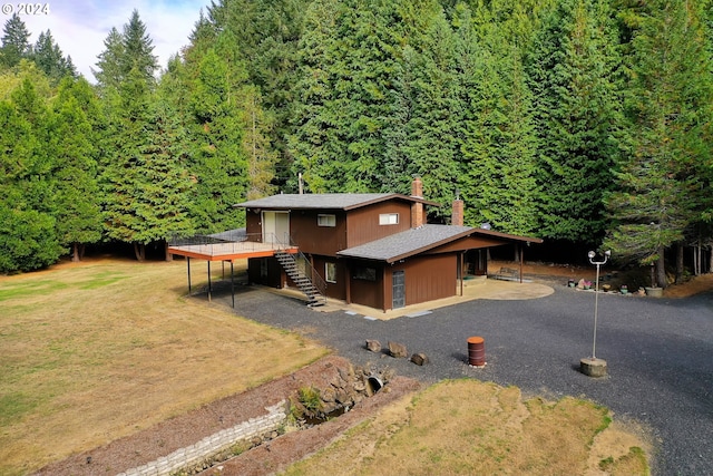 view of front of house featuring a patio and a front lawn