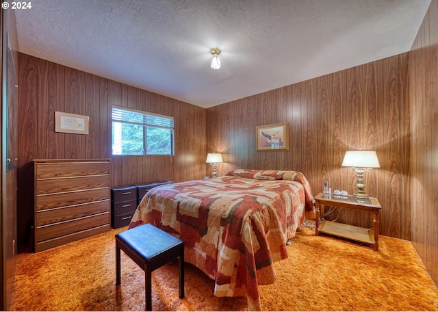 bedroom with carpet floors, wood walls, and a textured ceiling