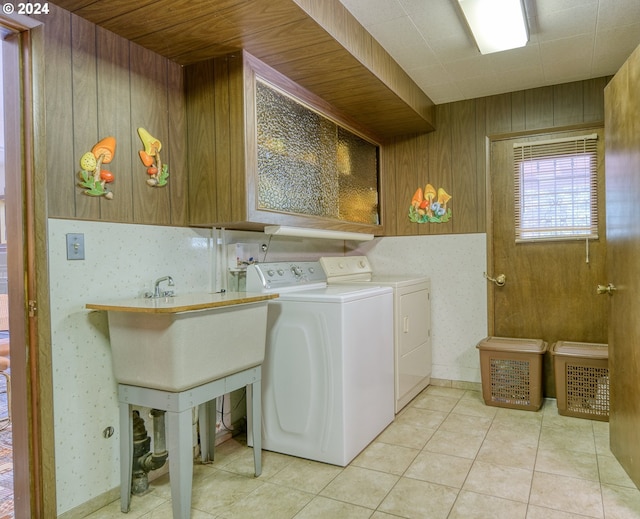 washroom featuring hookup for a washing machine, wooden walls, washing machine and dryer, and light tile floors