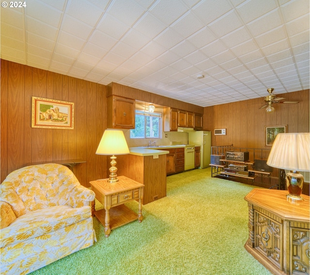 carpeted living room with wooden walls and ceiling fan