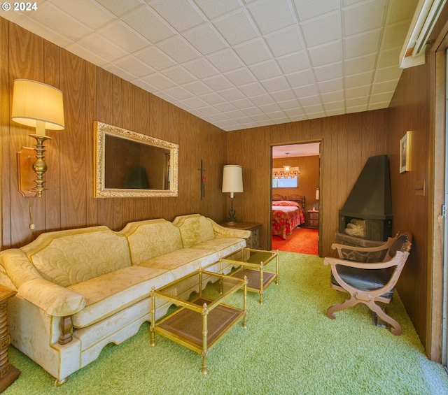 carpeted living room with wood walls