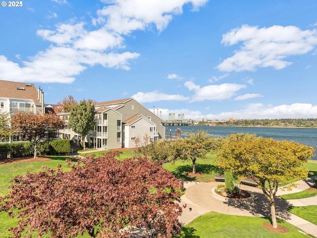 view of community with a yard and a water view