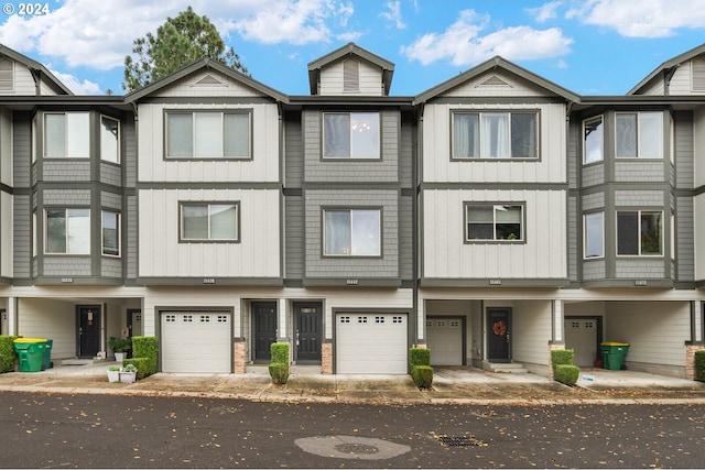 townhome / multi-family property featuring a garage and board and batten siding