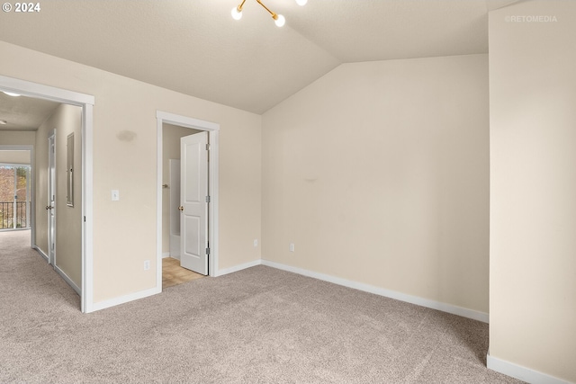 unfurnished bedroom featuring light carpet and vaulted ceiling