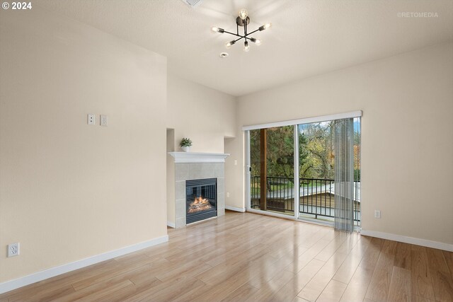 kitchen with kitchen peninsula, a chandelier, light hardwood / wood-style floors, a breakfast bar, and appliances with stainless steel finishes