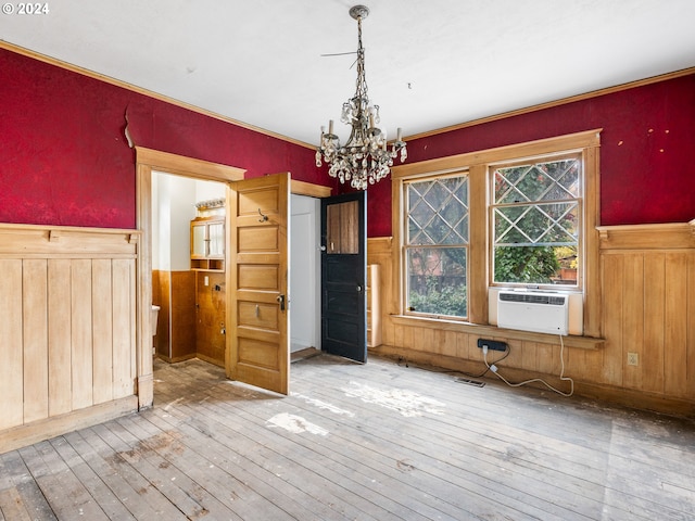 unfurnished dining area featuring hardwood / wood-style flooring, a healthy amount of sunlight, and a chandelier