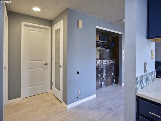 corridor featuring a textured ceiling, independent washer and dryer, and light hardwood / wood-style floors