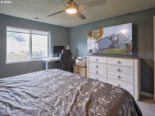 bedroom featuring ceiling fan and a textured ceiling