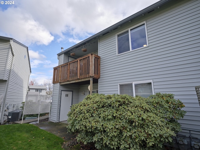 back of property with central AC and a balcony