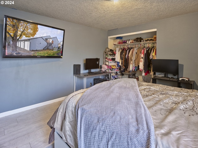 bedroom with light hardwood / wood-style flooring, a closet, and a textured ceiling