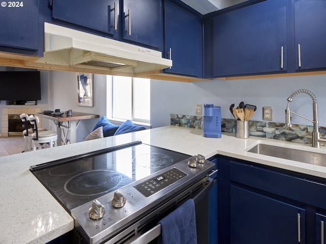 kitchen featuring light stone counters, sink, stainless steel electric range, and blue cabinetry