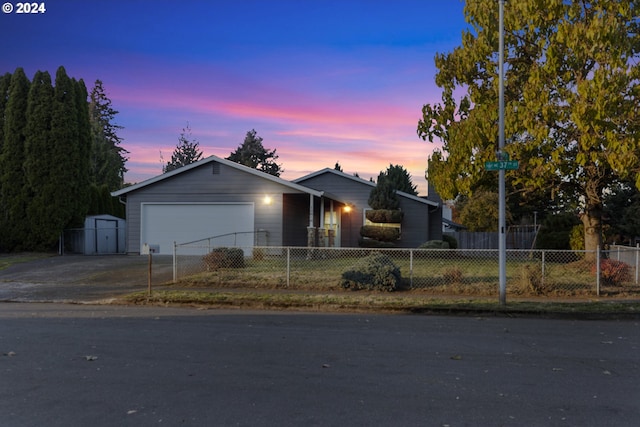 ranch-style house featuring a garage and a shed