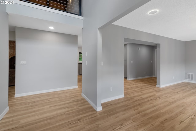 interior space with a towering ceiling and light hardwood / wood-style flooring