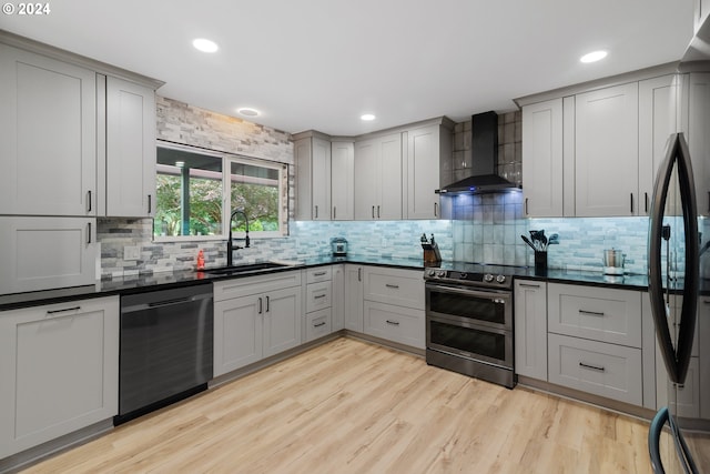 kitchen with dishwasher, wall chimney range hood, sink, double oven range, and gray cabinetry