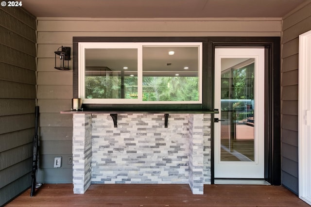 doorway to outside featuring wood-type flooring and wood walls