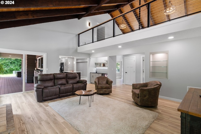 living room featuring high vaulted ceiling, plenty of natural light, beam ceiling, and light wood-type flooring