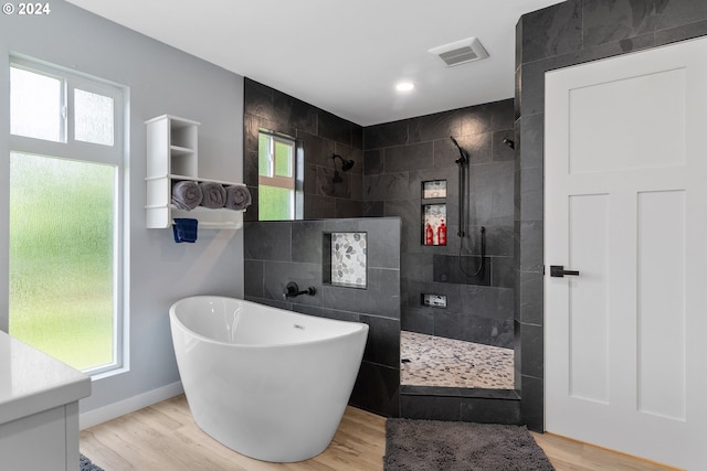 bathroom featuring plenty of natural light, wood-type flooring, vanity, and separate shower and tub