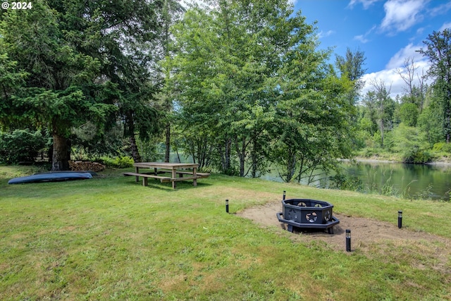 view of yard with a water view and an outdoor fire pit