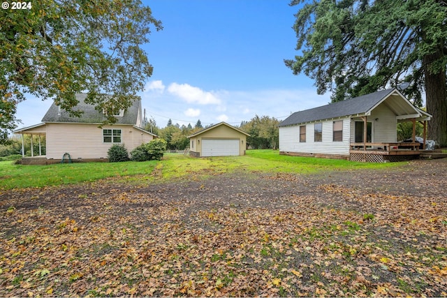 view of yard with an outdoor structure, a garage, and a wooden deck