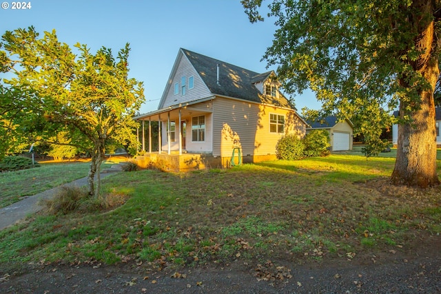 view of side of property featuring a garage, a porch, and a yard