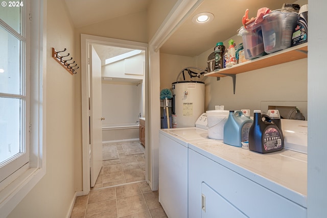 laundry area featuring washer and clothes dryer, water heater, and light tile patterned flooring