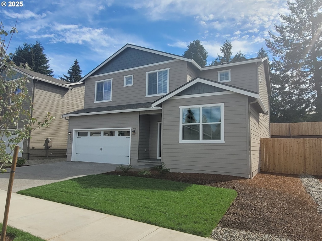 view of property featuring a garage and a front lawn