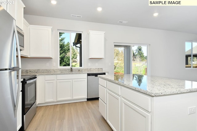 kitchen with a wealth of natural light, a center island, and stainless steel appliances