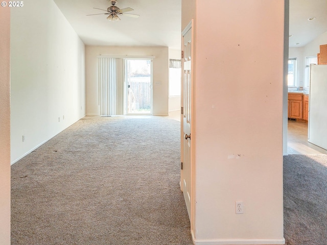 hall featuring sink and light colored carpet