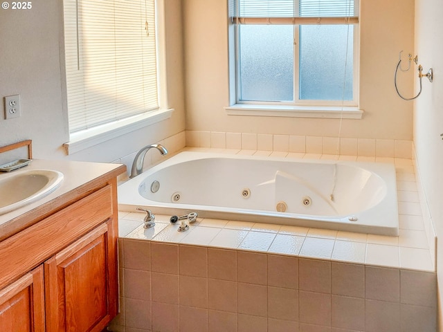 bathroom featuring a healthy amount of sunlight, vanity, and tiled tub