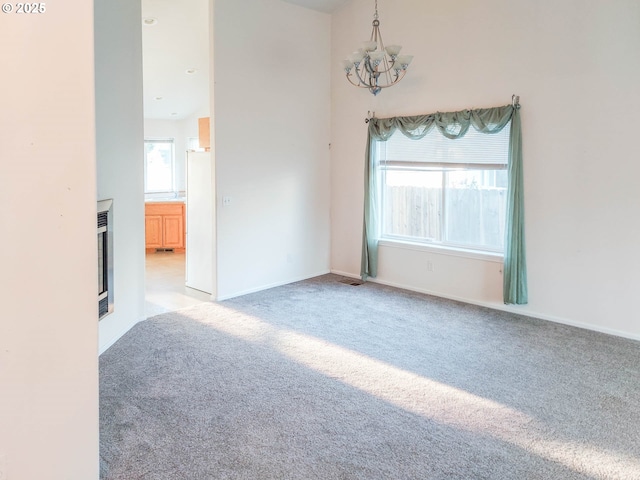 carpeted empty room with a chandelier