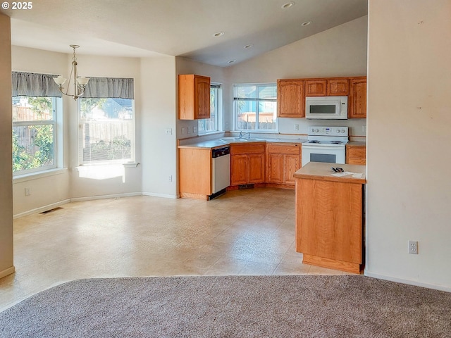 kitchen featuring sink, decorative light fixtures, vaulted ceiling, a notable chandelier, and white appliances