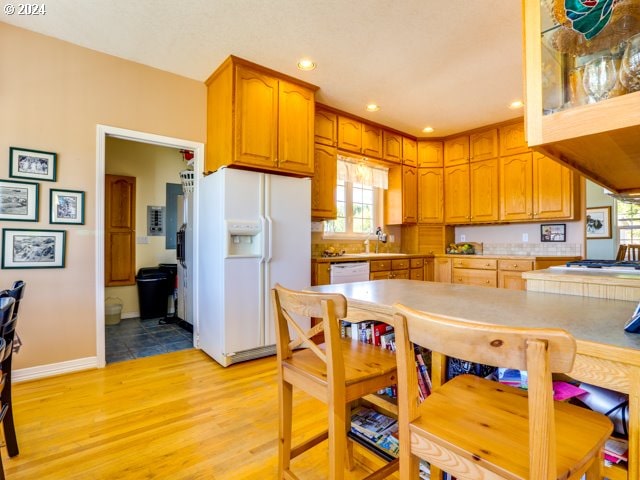 kitchen featuring sink, white appliances, and light wood-type flooring