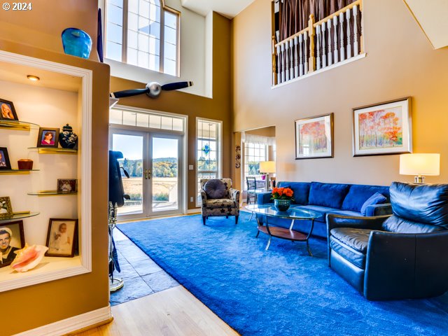 living room with french doors, hardwood / wood-style floors, and a high ceiling