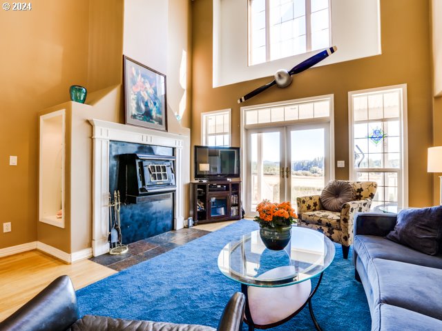 living room with french doors, a towering ceiling, and hardwood / wood-style floors