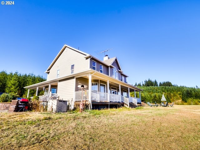 exterior space with covered porch and a yard