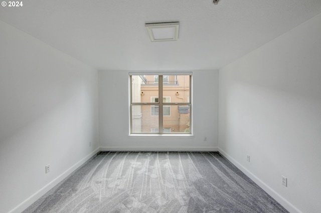carpeted spare room with baseboards