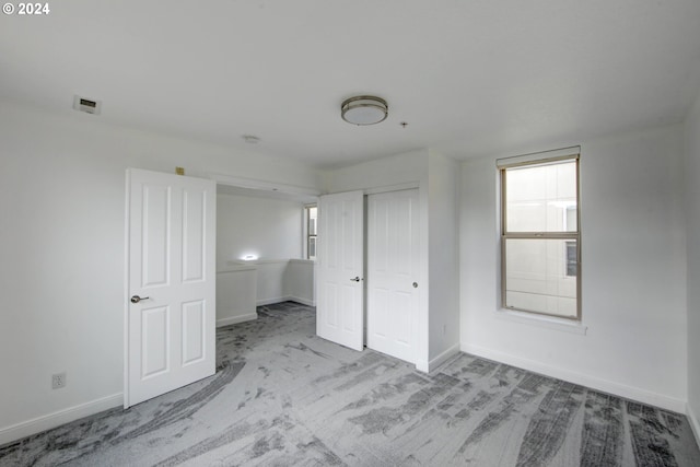 unfurnished bedroom featuring a closet, baseboards, and carpet