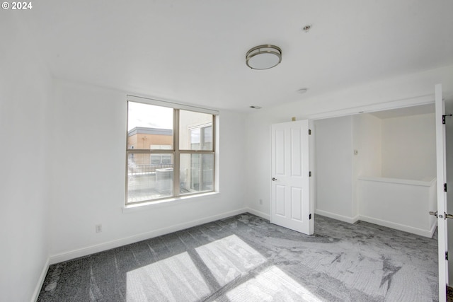 empty room with baseboards and carpet