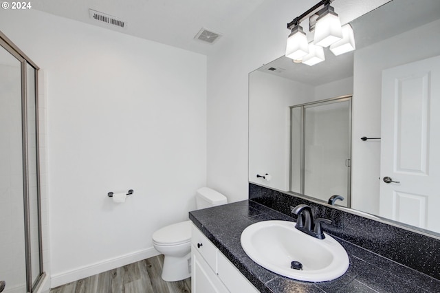 bathroom with vanity, toilet, an enclosed shower, and hardwood / wood-style floors