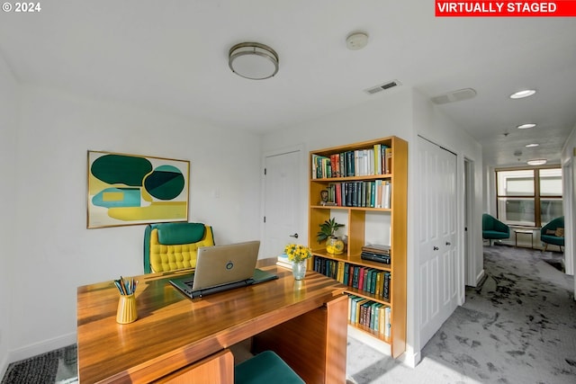 carpeted office featuring visible vents and baseboards
