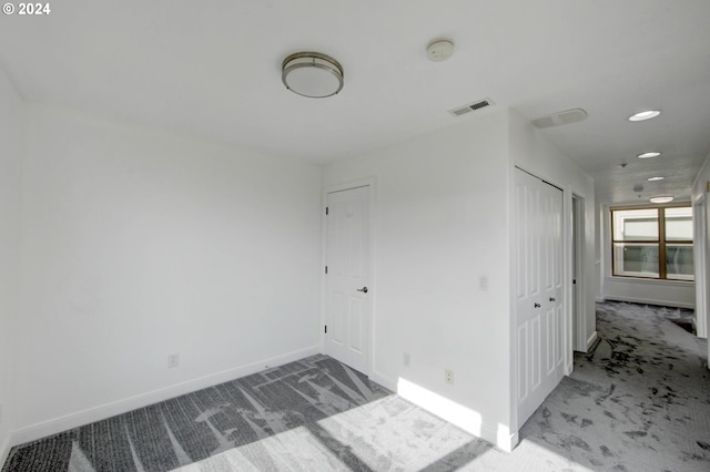 spare room with baseboards, visible vents, and carpet floors