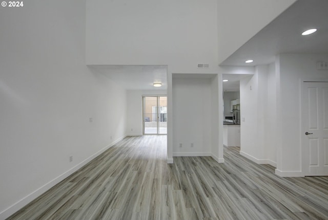 unfurnished living room with light wood finished floors, baseboards, visible vents, and recessed lighting
